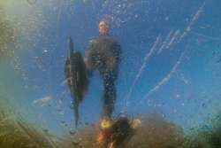 An picture taken from under ice of a skater. Never seen s... by Brenda De Vries 